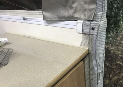 Cut magnetic fly screen along top of caravan cupboard